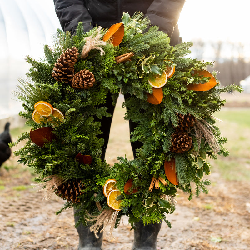 Handmade woodland evergreen wreath with pinecones, dried orange slices and natural foliage.